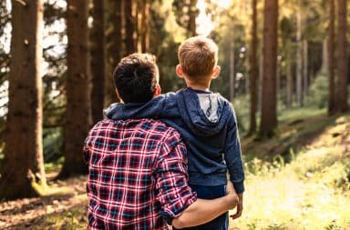 Un père et son fils tissent des liens dans la forêt.