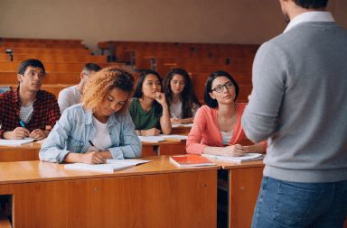 Étudiants attentifs en salle de classe écoutant un enseignant, illustrant les débats autour de l’organisation du temps scolaire et de l’apprentissage.