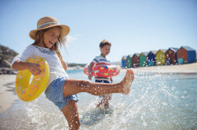 Enfants jouant au bord de la mer pendant des vacances en famille rendues possibles grâce aux aides de la CAF