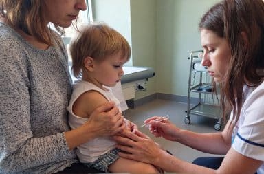 Vaccin enfant : professionnel de santé administrant un vaccin à un jeune enfant accompagné de son parent