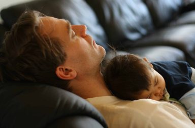 jeune père fatigué avec son bébé endormi illustrant l’anxiété paternelle après la naissance